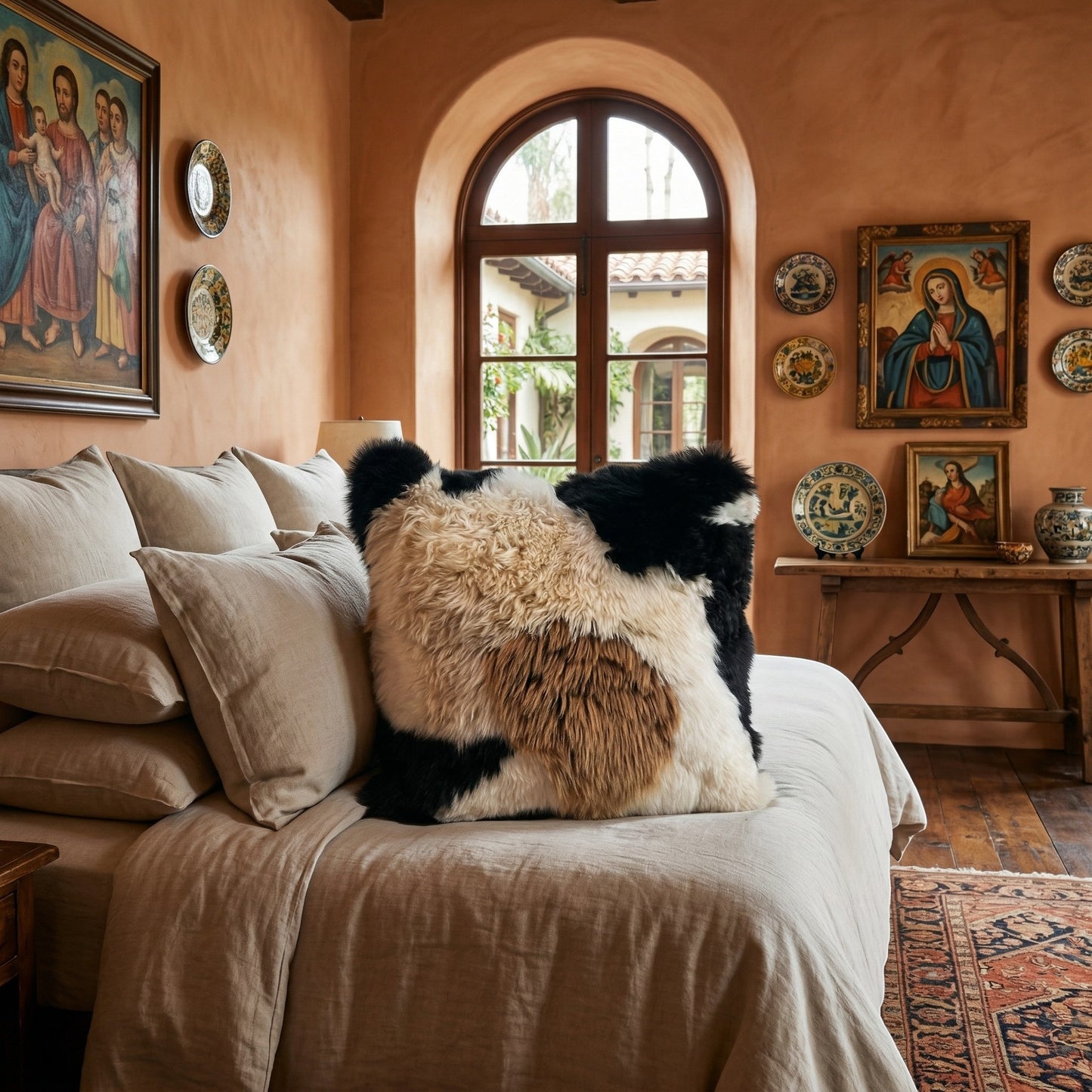 Peruvian Accent black, white, and brown baby alpaca fur pillow on a bed. Fur on one side, 20x20 inches.