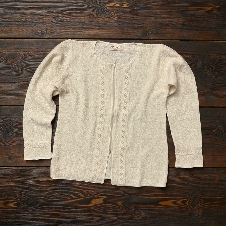 100% PERUVIAN pima cotton zip up  top laying flat on a wood counter.
