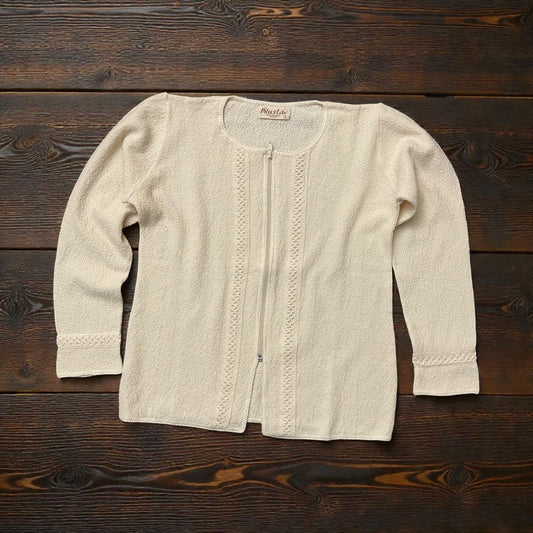 100% PERUVIAN pima cotton zip up top laying flat on a wood counter.