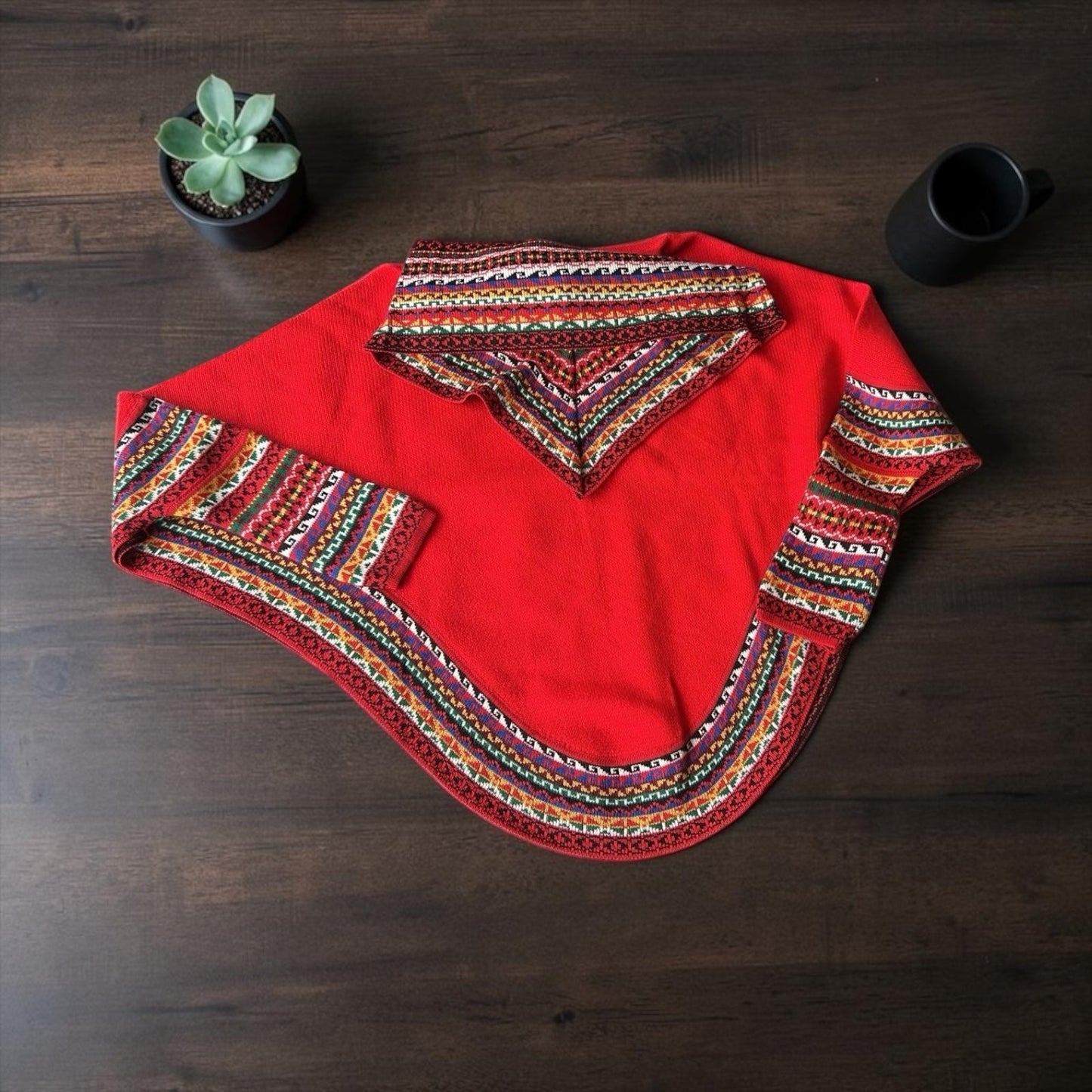 Peruvian Accent red alpaca poncho with sleeves, featuring colorful geometric embroidery on the collar, cuffs, and hem. Elegant cowl neck design.