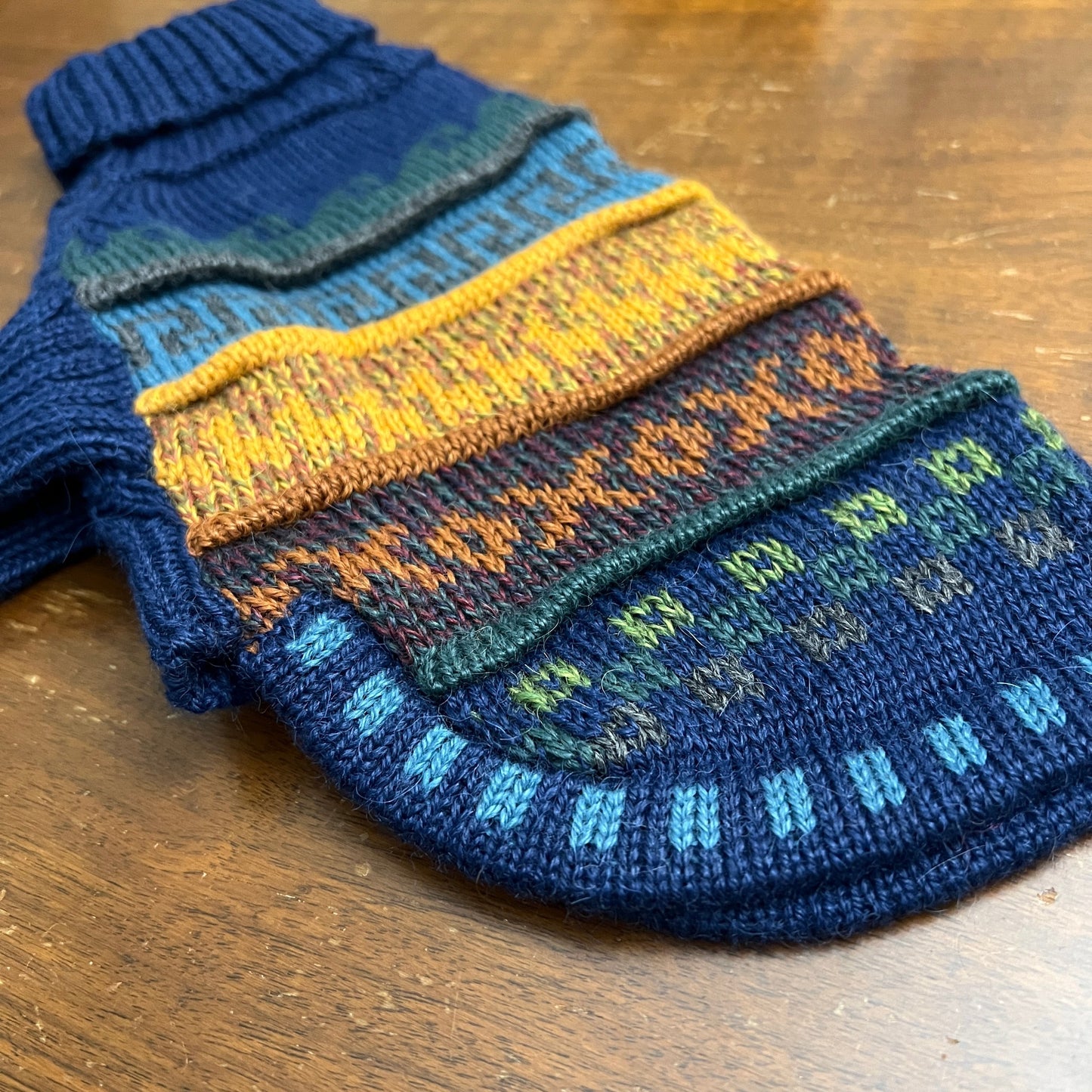 Peruvian Accent navy blue quarter sleeve dog sweater with colorful Andean patterns, made from alpaca wool.