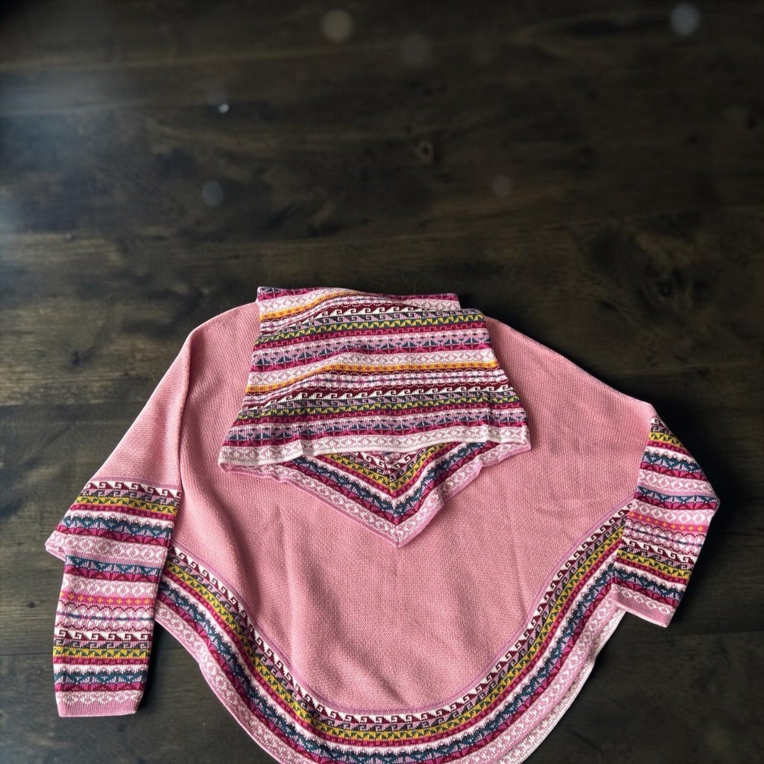 Peruvian Accent pink alpaca poncho with sleeves and cowl neck, featuring a colorful geometric pattern trim.