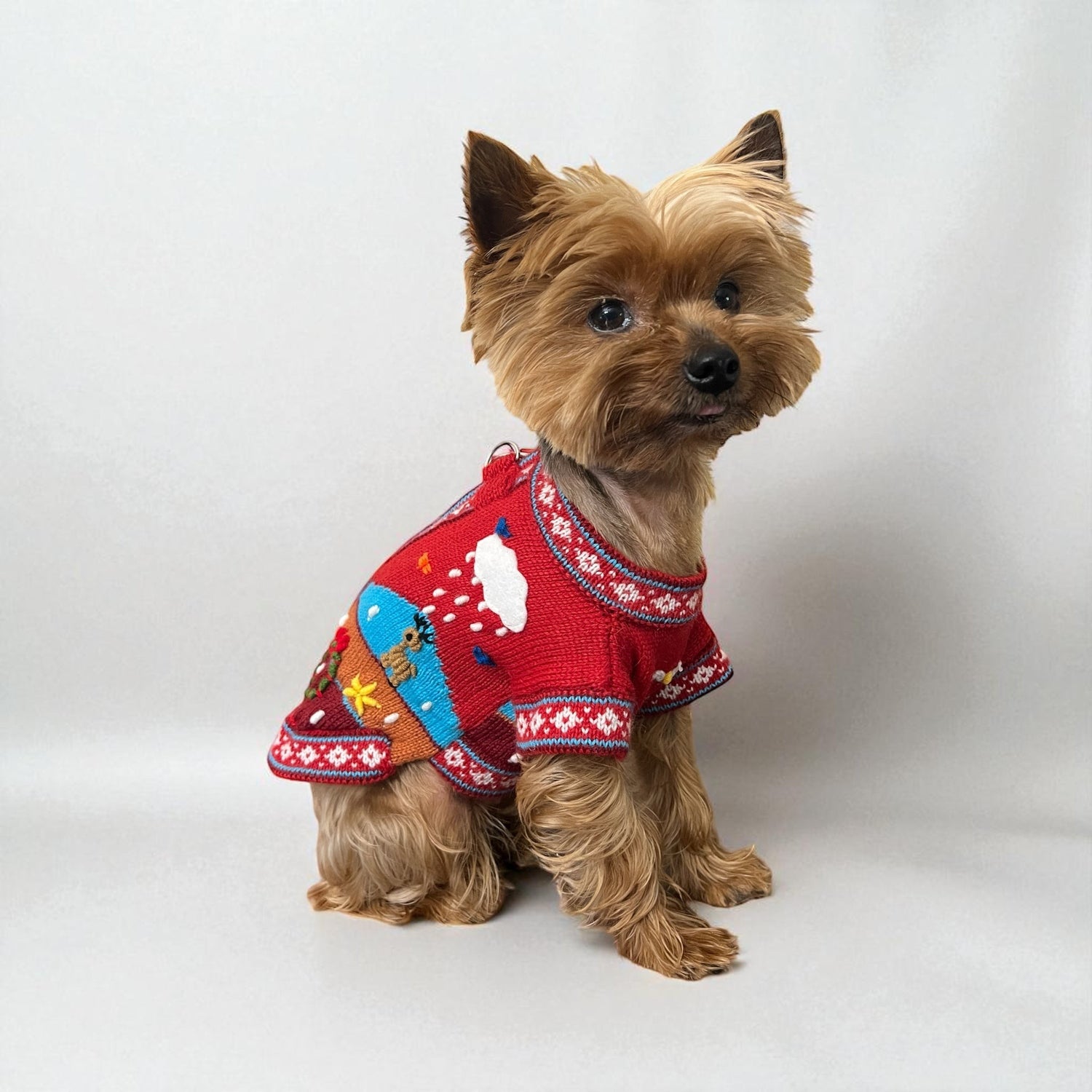 Peruvian Accent red alpaca dog sweater with festive holiday designs including snowmen, snowflakes, and reindeer. Zip-up style.