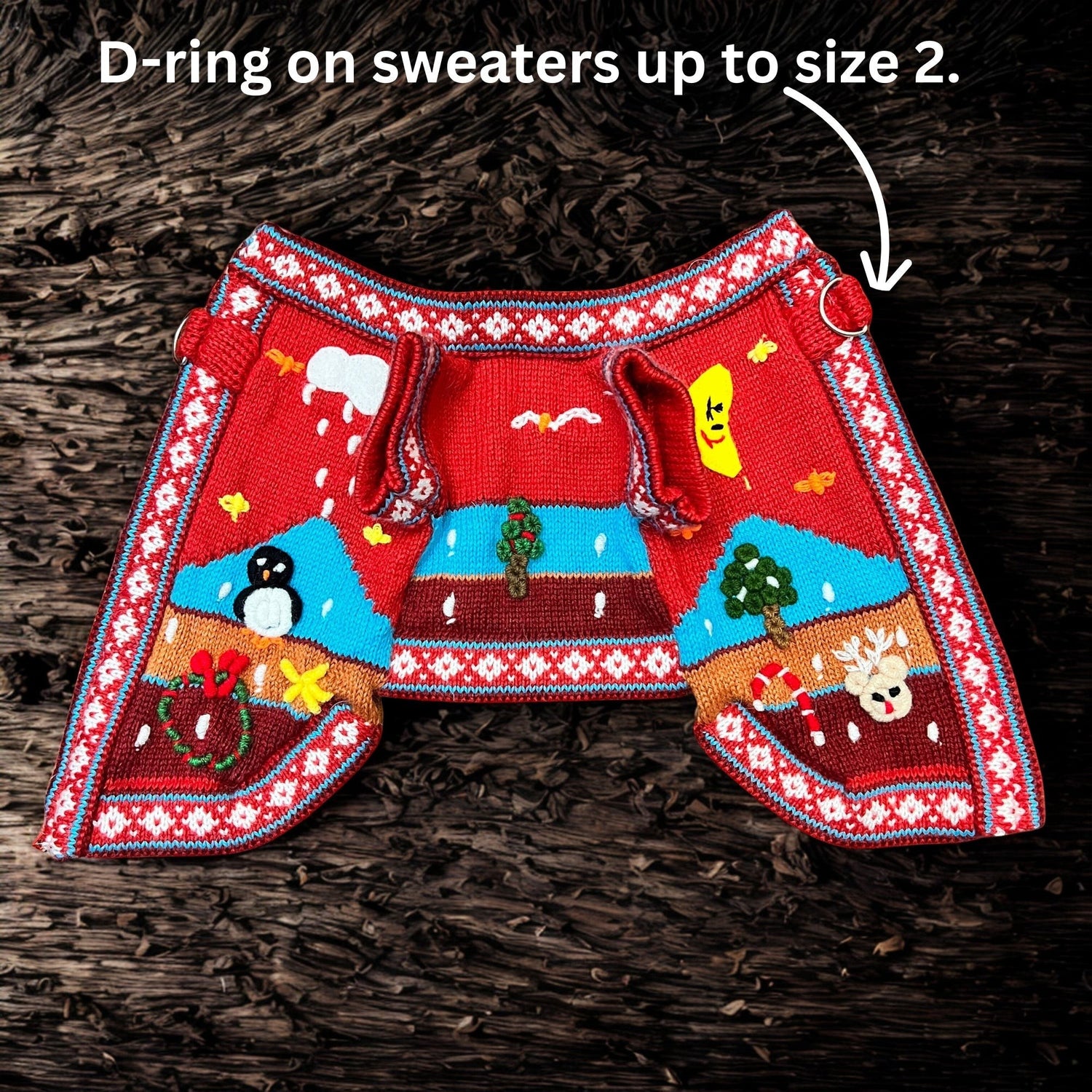 Peruvian Accent red alpaca dog sweater with holiday motifs like penguins, reindeer, snowmen, and candy canes. Features a zip-up back and D-rings on smaller sizes.