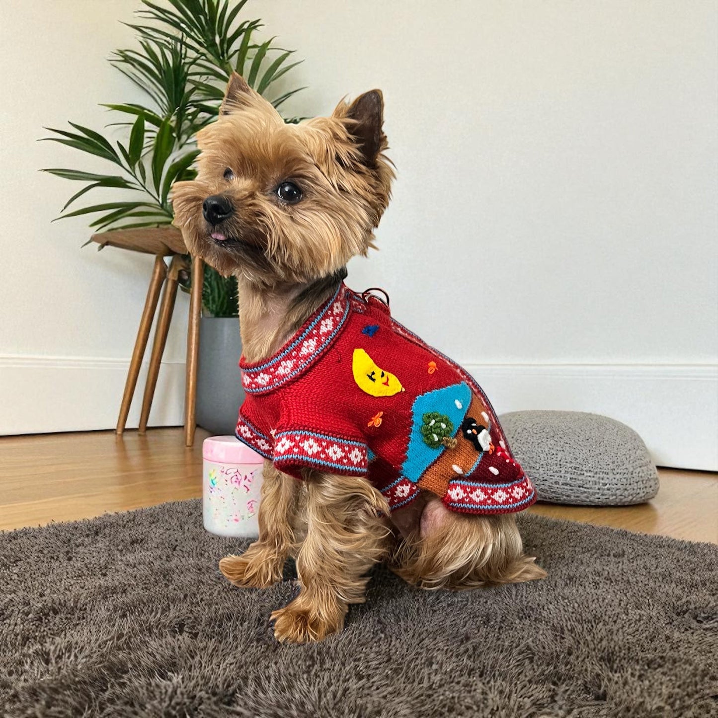 Peruvian Accent red alpaca zip-up dog sweater with Nazca-inspired holiday designs including a snowman, moon, and reindeer.