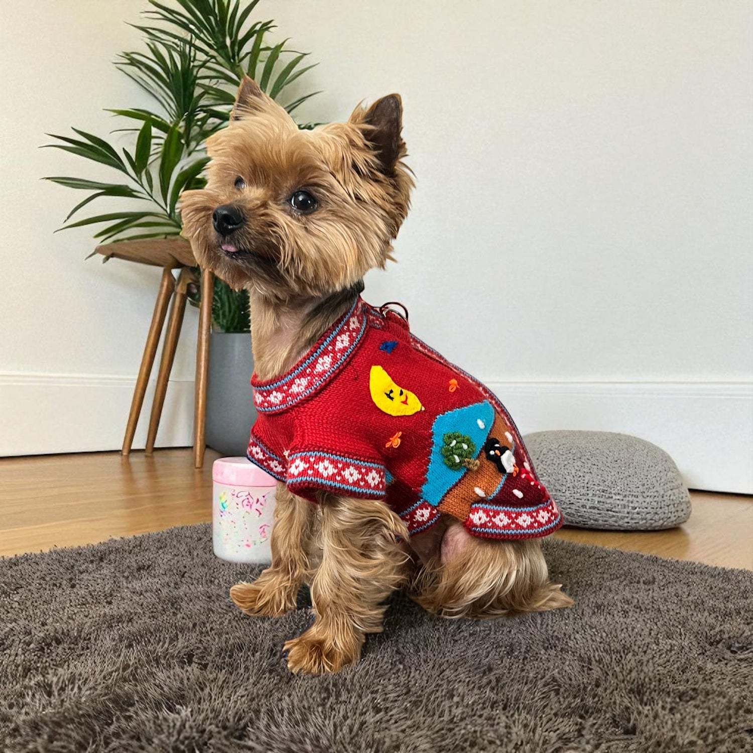 Peruvian Accent red alpaca zip-up dog sweater with Nazca-inspired holiday designs including a snowman, moon, and reindeer.
